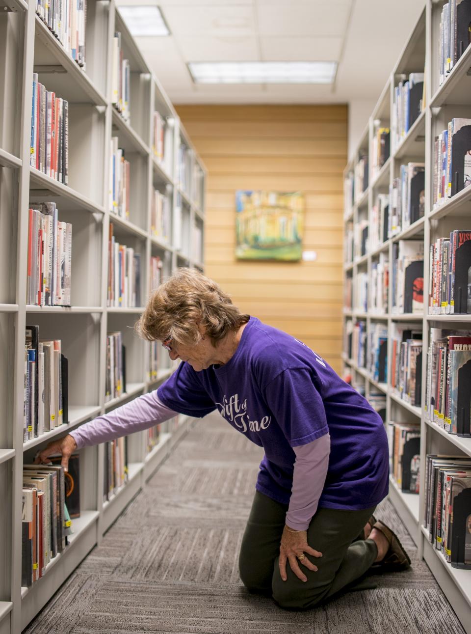 Woman looking for a book in the book stacks