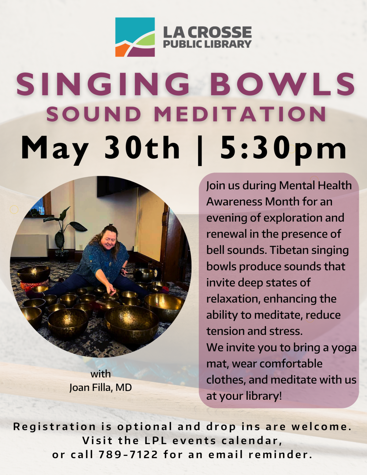 seated woman smiles and plays sound bowls